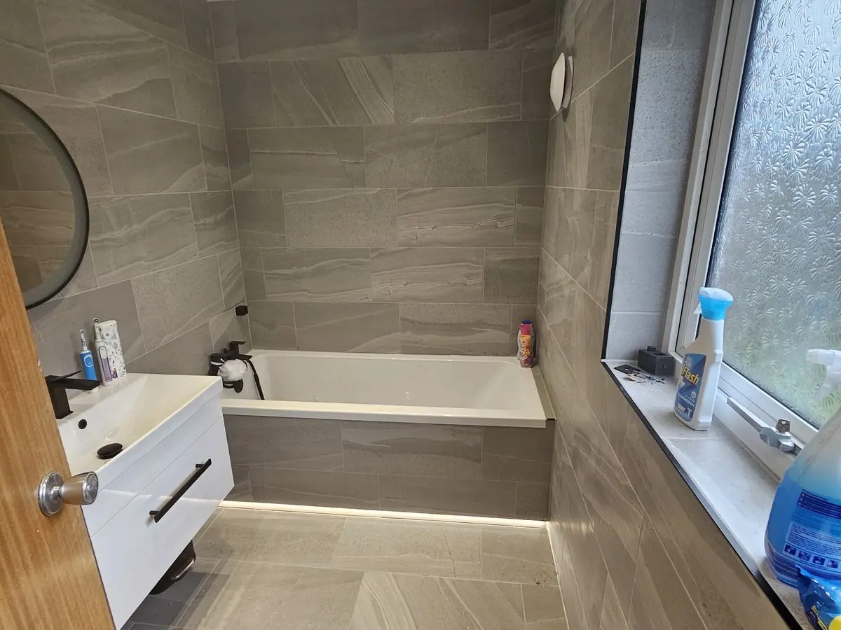 Family bathroom fully tiled in large-format stone-effect tiles