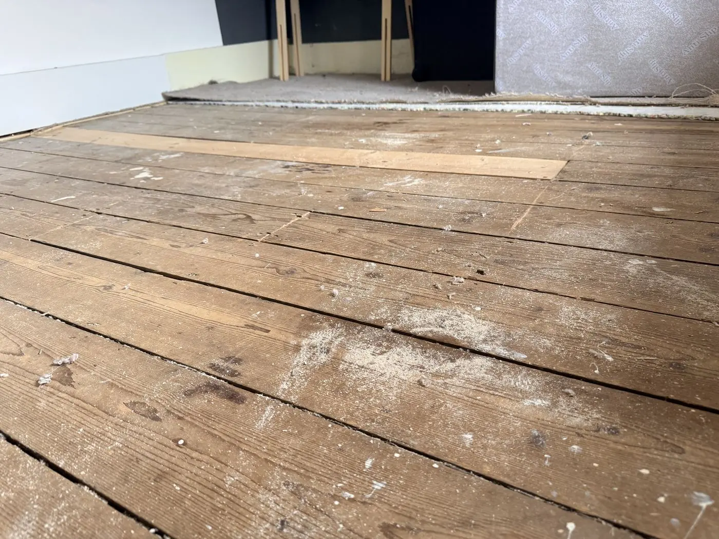 Bare floorboards after the old carpet was lifted