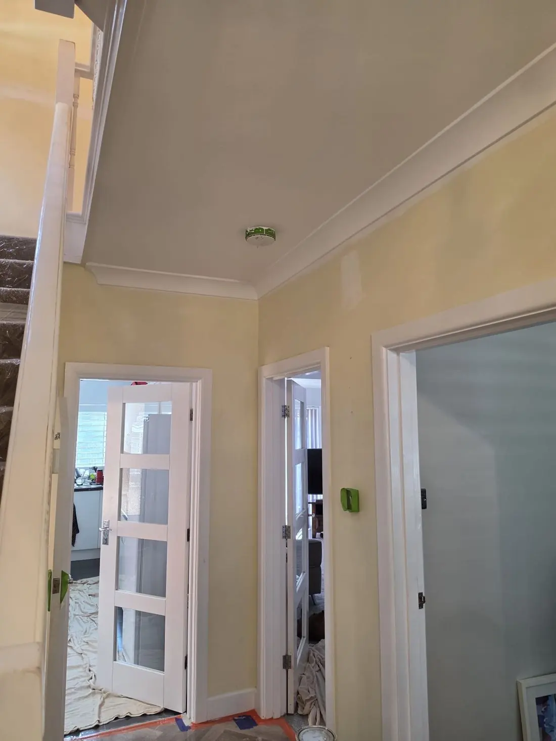 Hallway before work, with tired yellow walls and dust sheets down
